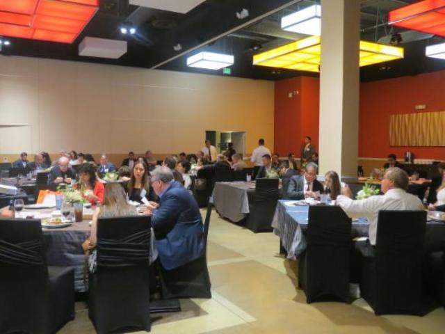 Audience attending lunch and presentation in large dining hall
